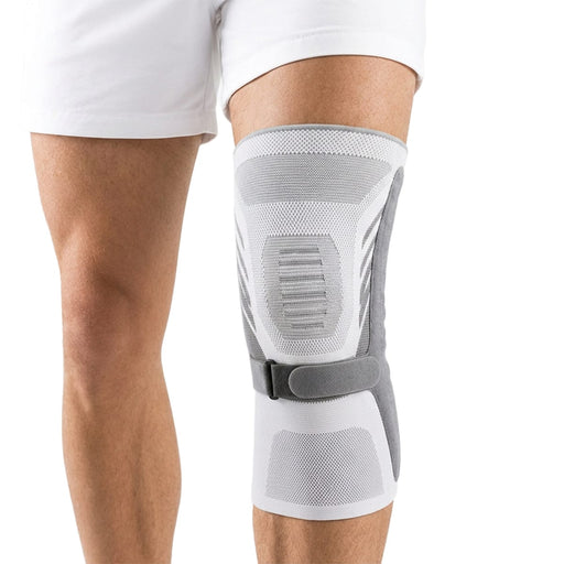 Person med knebeskytter med spenne på høyre kne, iført hvite shorts.