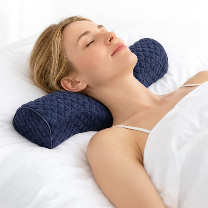 En kvinne hviler med en ergonomisk, polstret nakkestøtte i memory foam i mørkeblå farge.