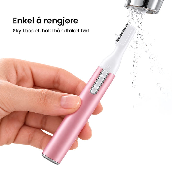 En hånd holder en rosa elektrisk presisjonstrimmer, mens vann renner over trimmerhodet.