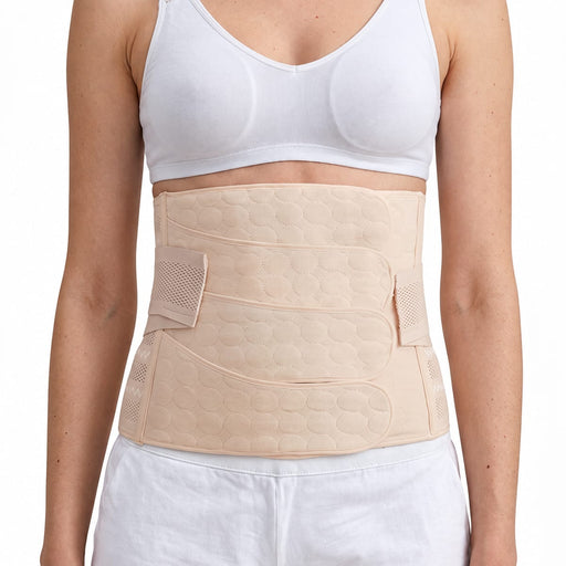 Kvinne med magebelte etter fødsel, brukt over en hvit BH og shorts for ekstra støtte.