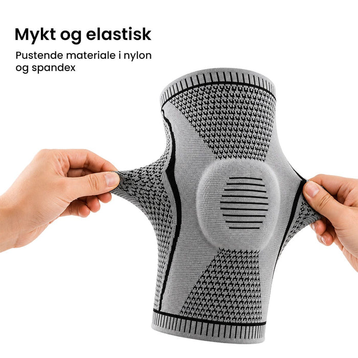 En person som tar på seg en grå, elastisk knebeskytter med kompresjon og forsterket kneskål.