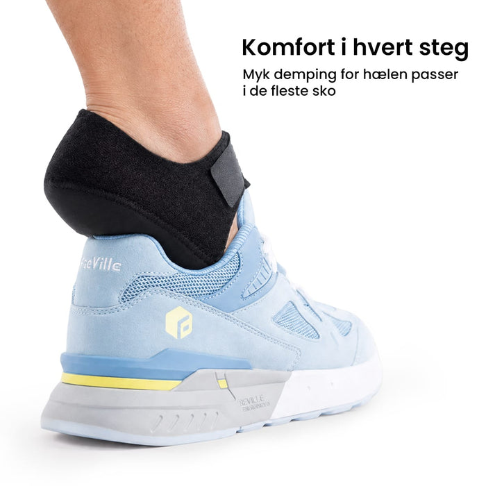 Hælbeskyttelse i silikon plassert inne i en lyseblå joggesko.